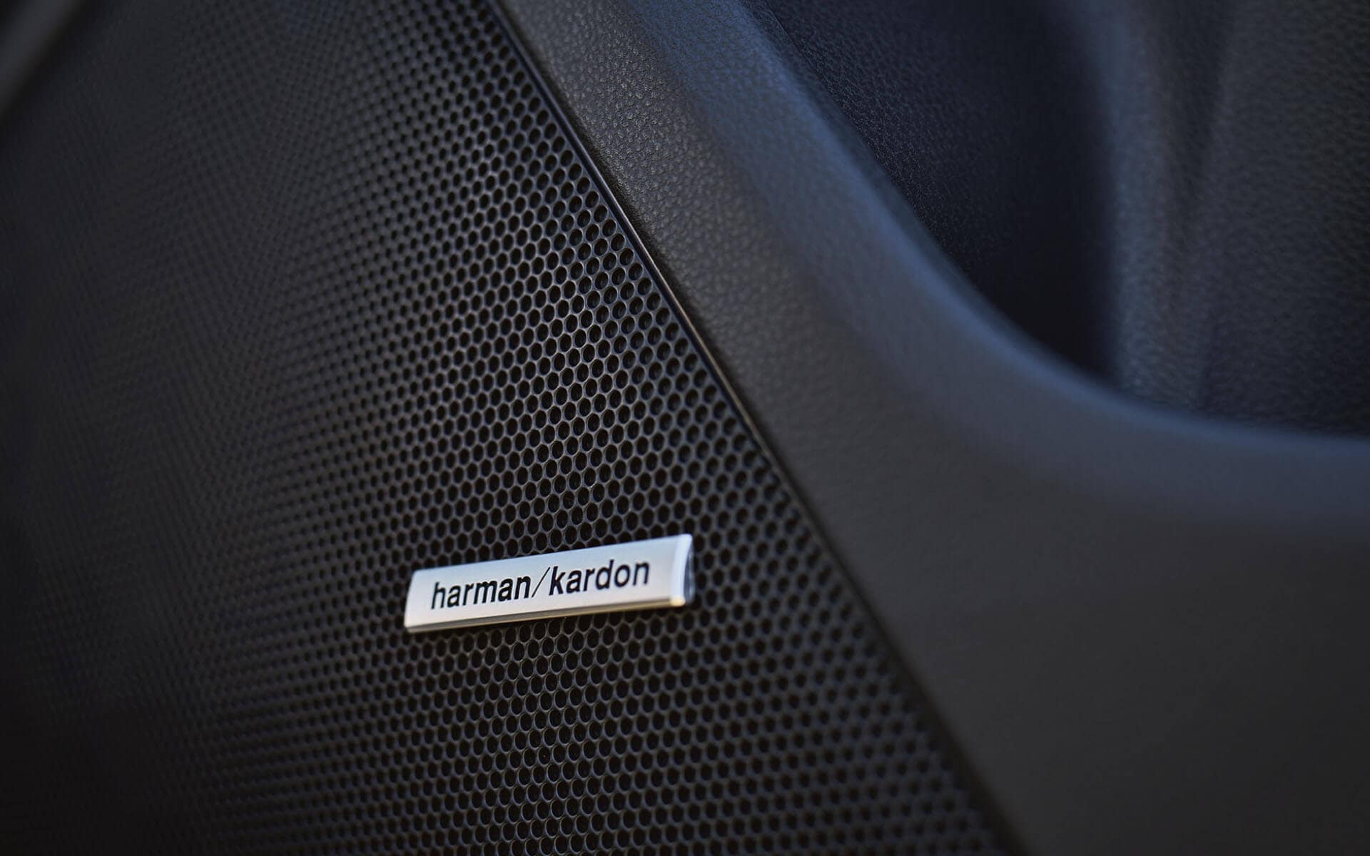 An extreme closeup of a Harman Kardon speaker in a Subaru Crosstrek